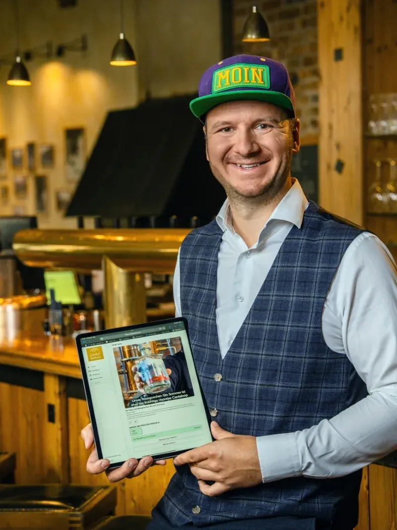 Christoph Digwa zeigt die Menoovo-Gastberatung auf einem Tablet im Restaurant.